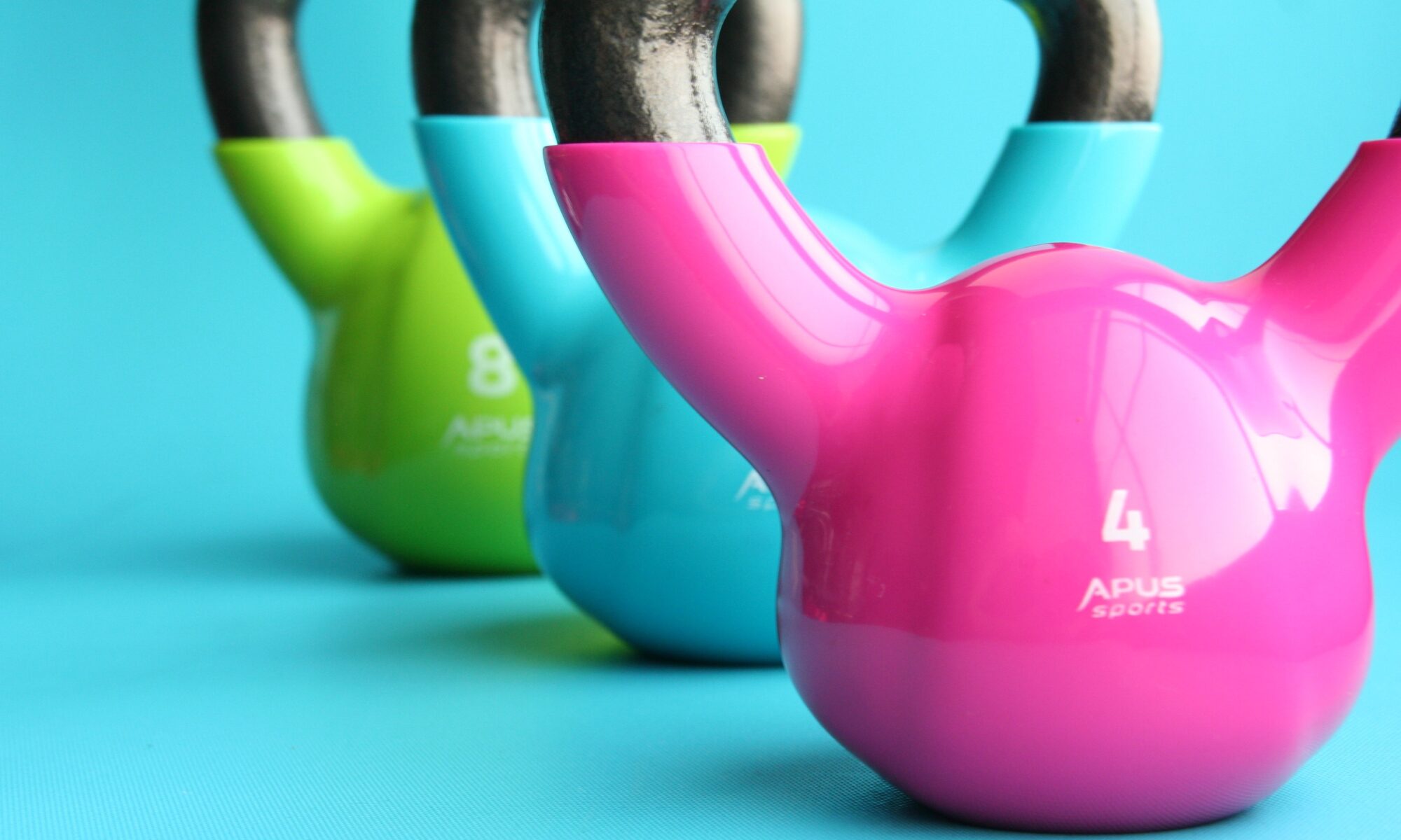 Green, blue, and pink kettle bells