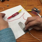 Paper, pencil, alligator clips, and lightbulb from snap circuit